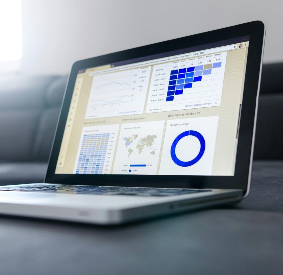 Laptop mit Diagrammen und Grafiken auf einem hellen Hintergrund.