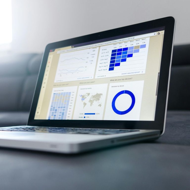 Ein Laptop zeigt verschiedene Datenanalysen und Diagramme auf dem Bildschirm.