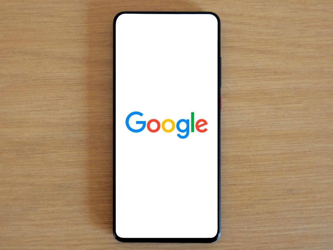 Smartphone mit Google-Logo auf weißem Hintergrund.