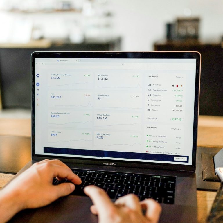 Ein Laptop zeigt eine Übersicht mit Tabellen und Daten auf dem Bildschirm.