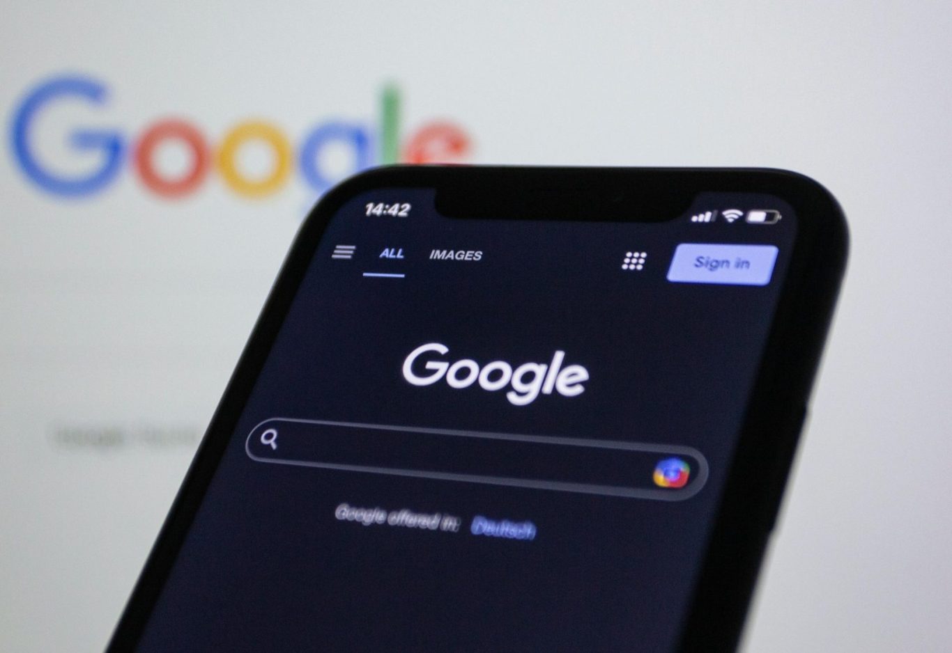 Ein Smartphone zeigt die Google-Website im dunklen Modus.